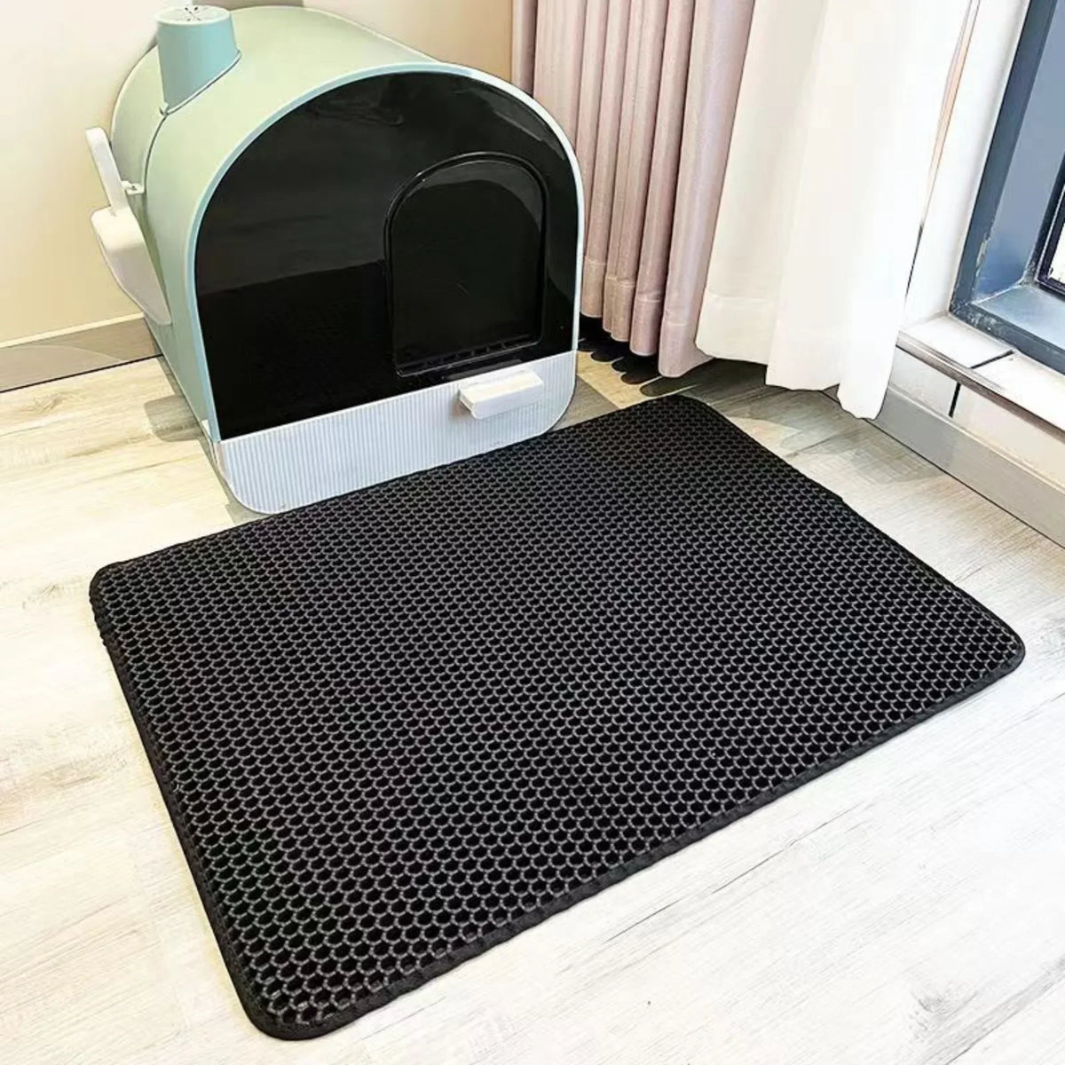 Black double-layer litter mat in front of a litter box