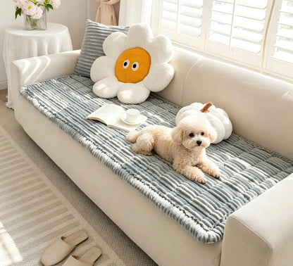 Light grey padded flannel couch cover with a small dog resting on the sofa