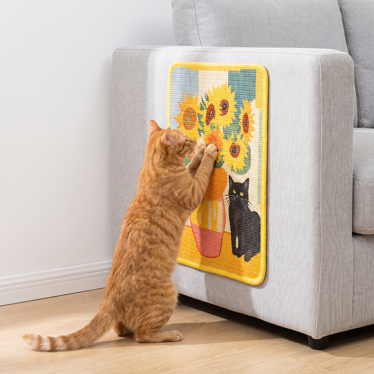 Orange cat scratching the Sunflowers art print scratcher on a sofa side